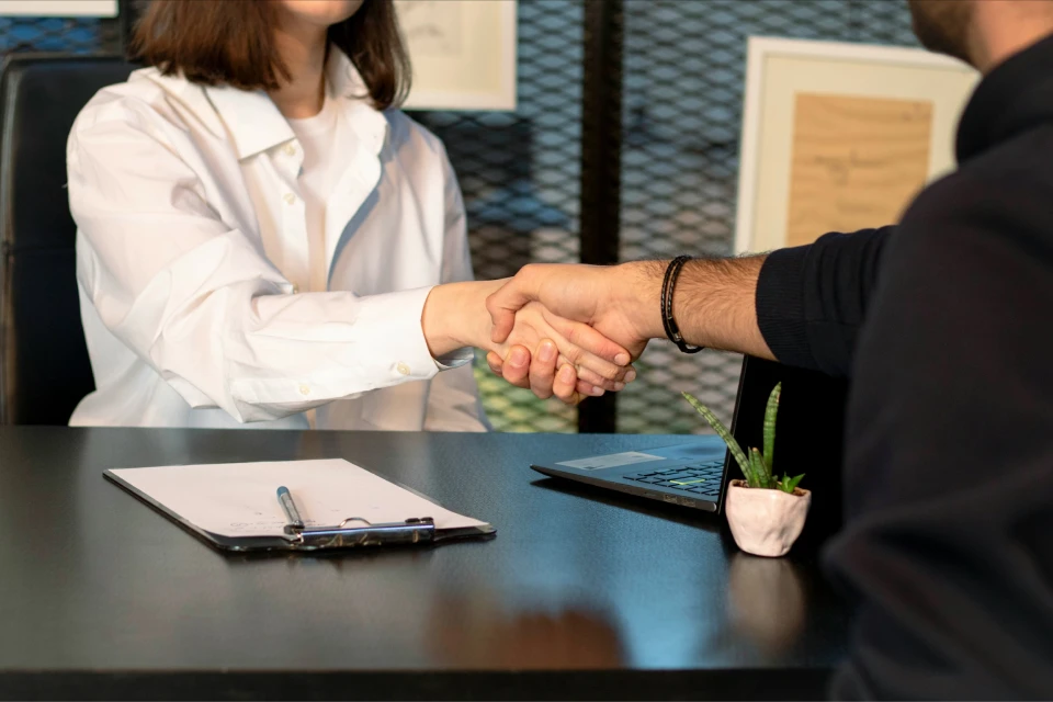 Poignée de main entre une professionnelle et un étudiant